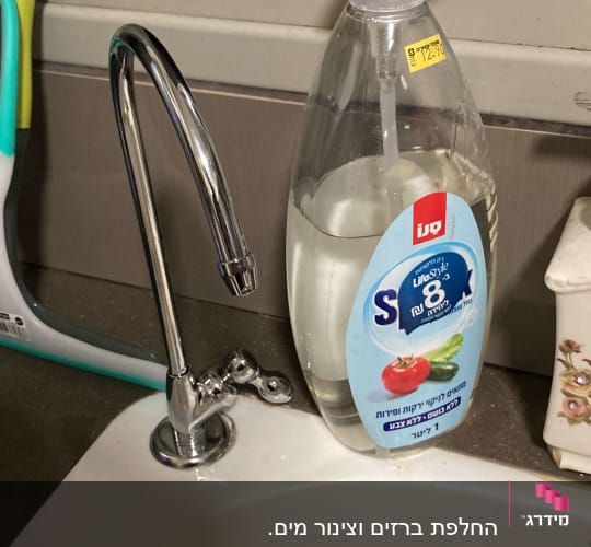 ברז נירוסטה ליד כיור עם סבון נוזלי